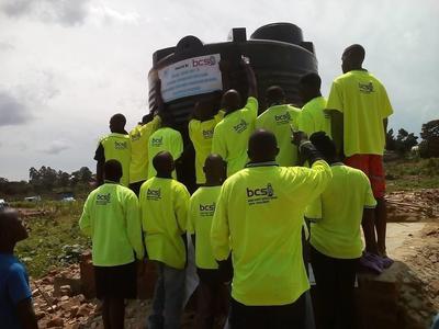 Jonathan Mugerwa leading volunteers to present a water tank in Uganda 